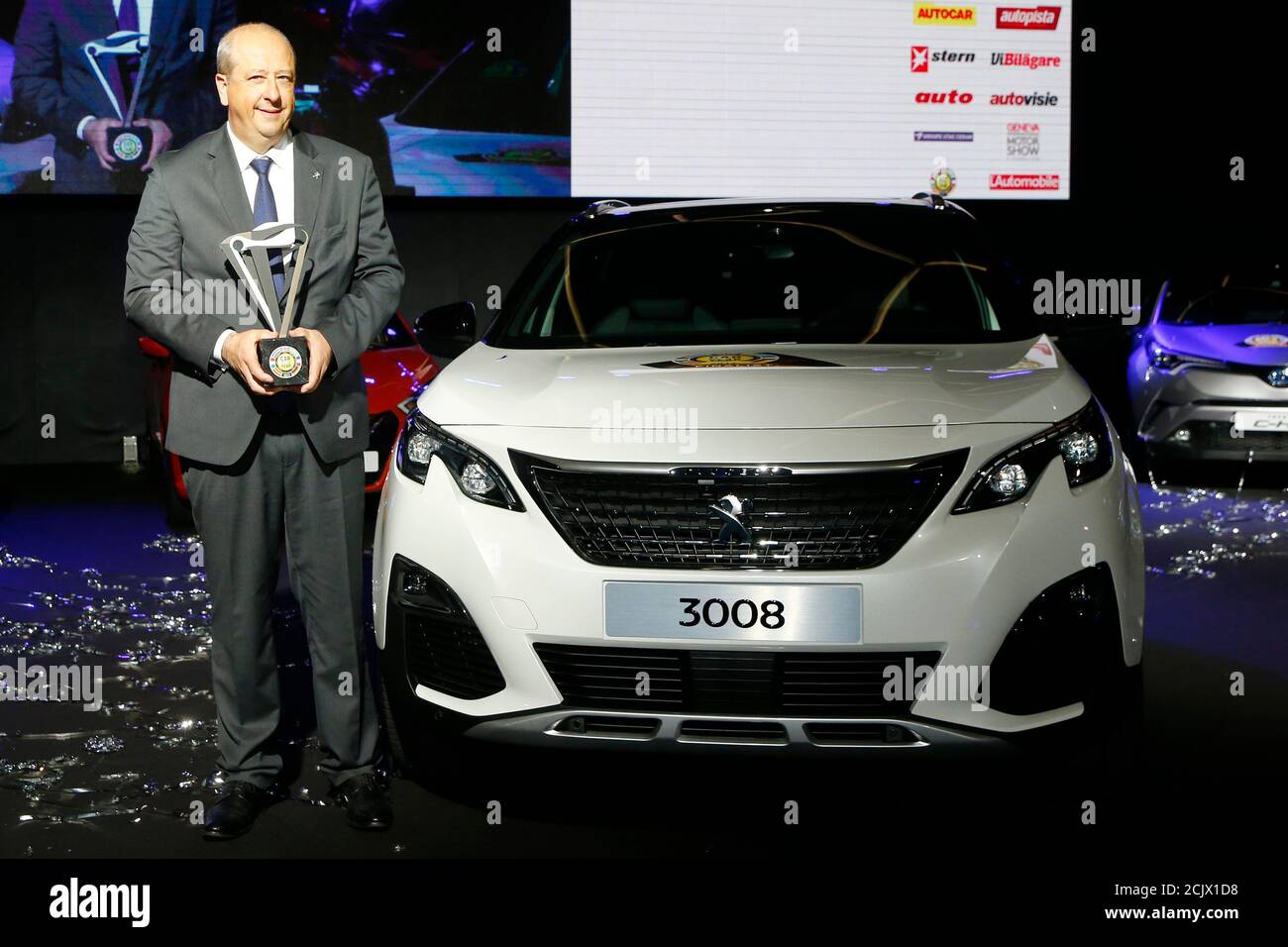 Jean-Philippe Imparato, CEO Peugeot brand, poses with the Car of the Year  award next to the Peugeot 3008 during the presentation, ahead of the 87th  International Motor Show at Palexpo in Geneva,