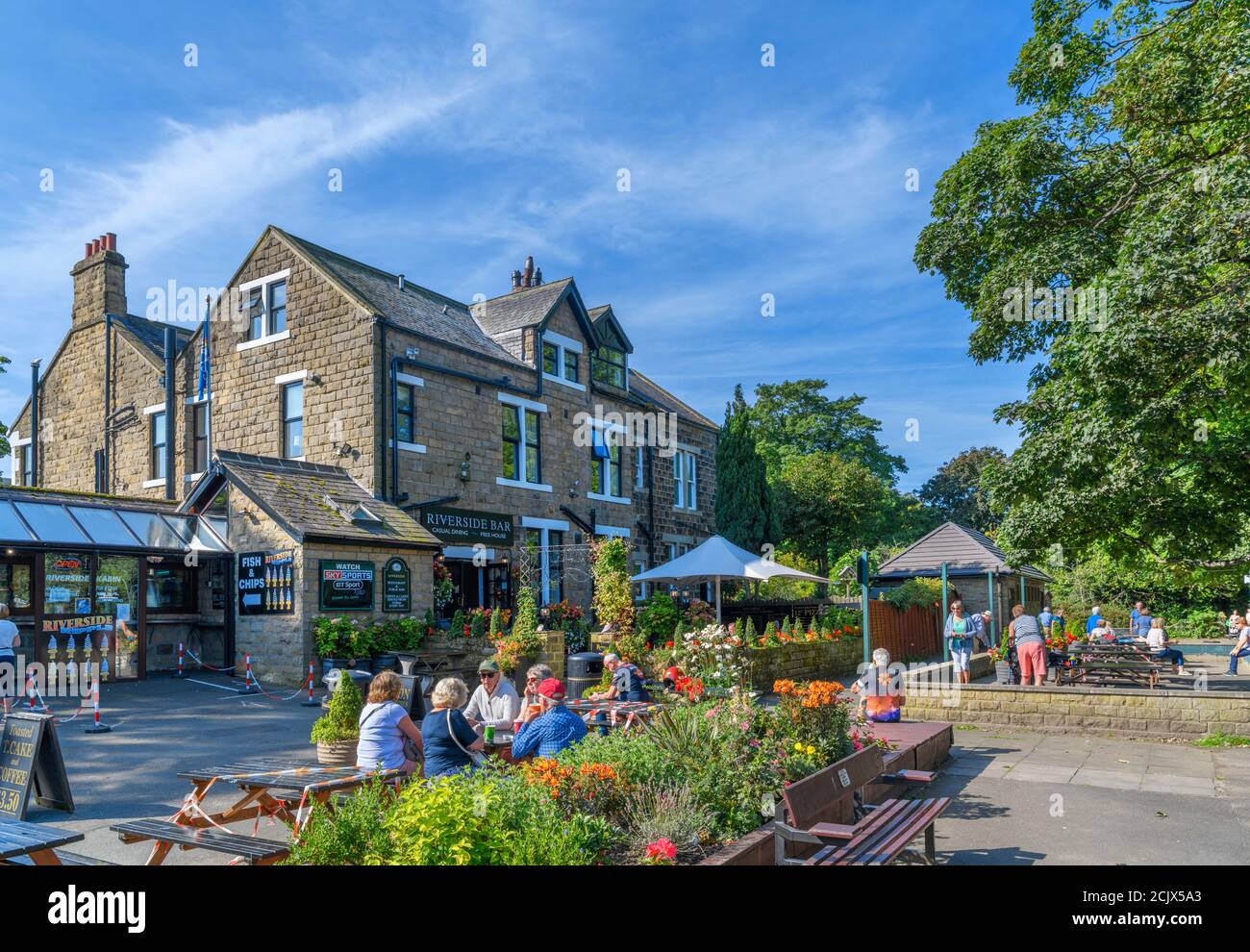 People sitting outside the Riverside Bar at the Riverside Hotel on the Dales Way, Ilkley, North Yorkshire, England, UK. Stock Photo