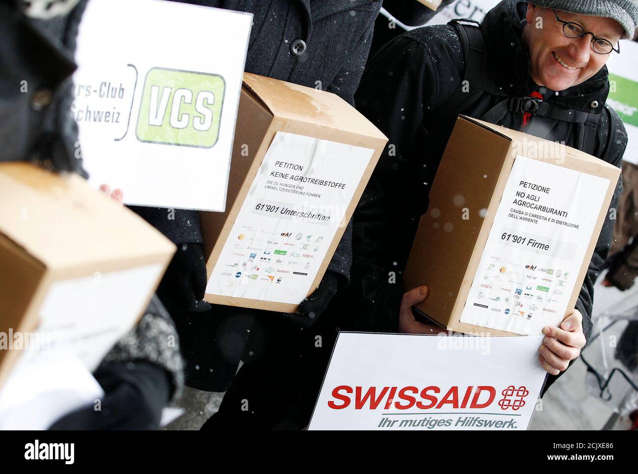 Members of the different aid organisation carry boxes with 61,901 signatures of the signed petition 'No agro fuels - no hunger and no destruction of the environment' ('Keine Agrotreibstoffe, die zu Hunger und Umweltzerstoerung fuehren') outside the parliament building in Bern February 24, 2011. REUTERS/Pascal Lauener (SWITZERLAND - Tags: POLITICS CIVIL UNREST ENVIRONMENT) Stock Photo