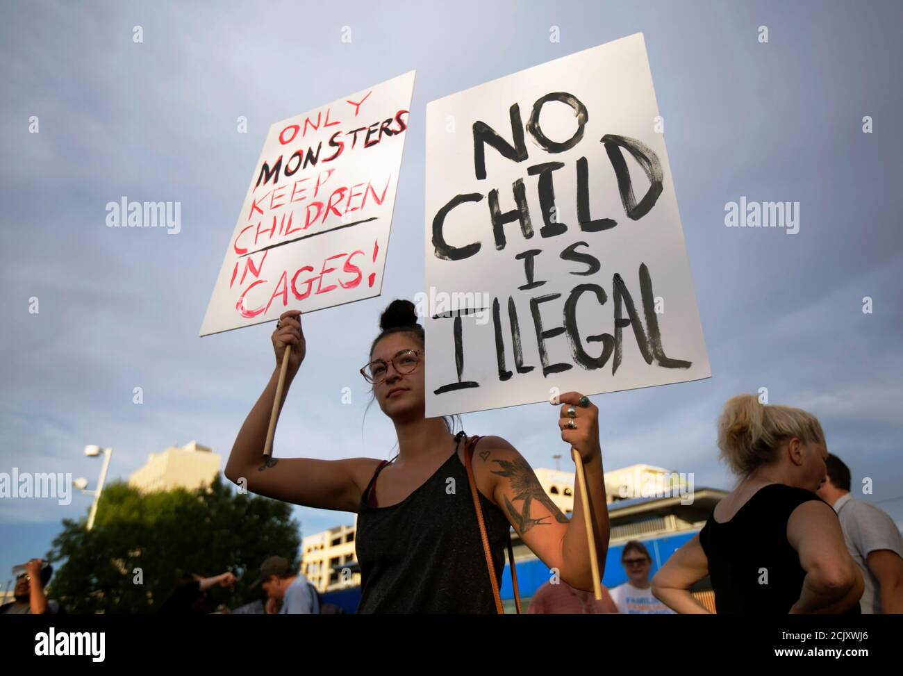 A protester holds placards during an immigration rights rally at Cleveland Square Park in El Paso, Texas, U.S. July 12, 2019. REUTERS/Daniel Becerril Stock Photo