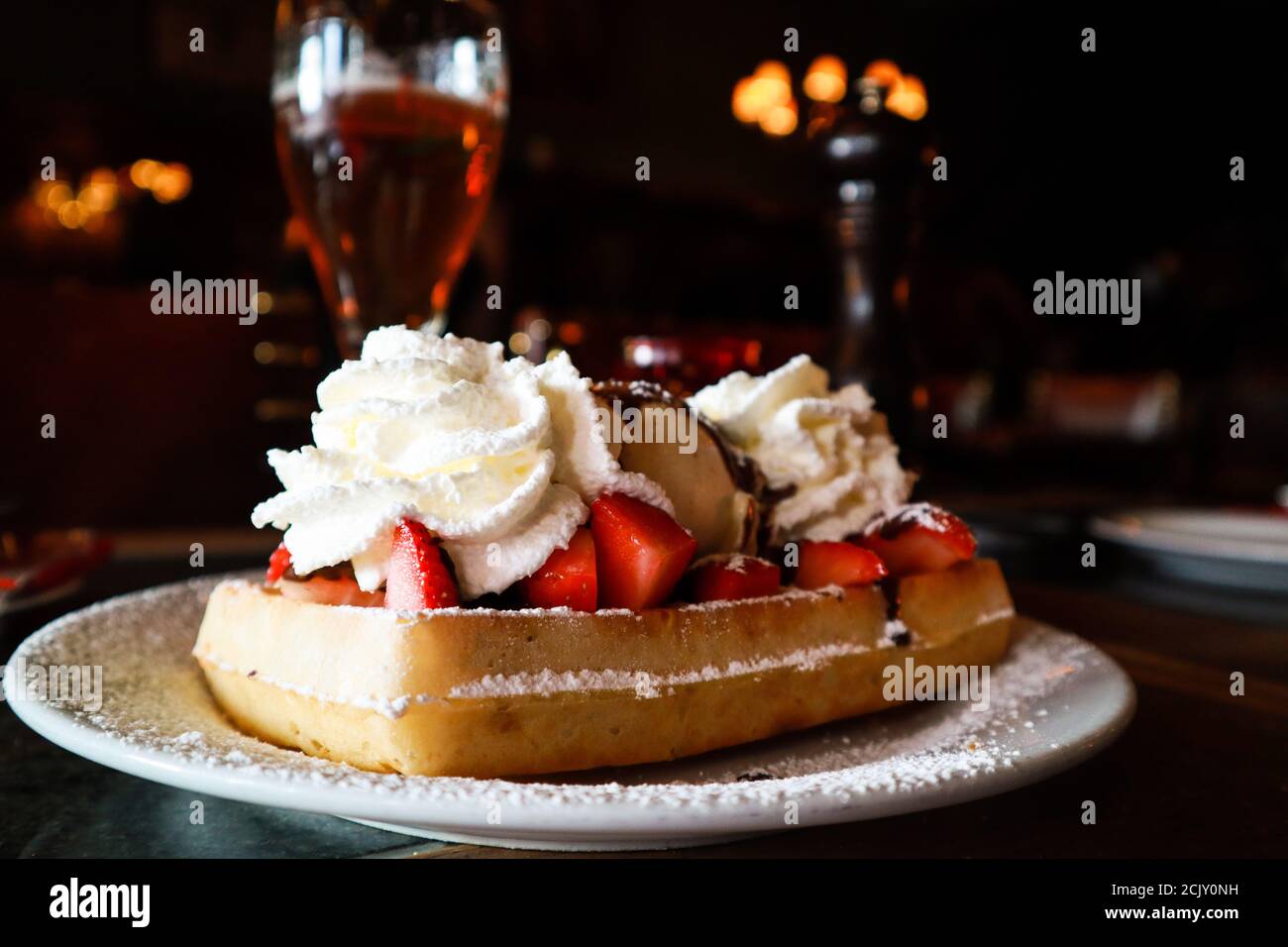Waffle with strawberries, cream and beer in a restaurant in Bruges