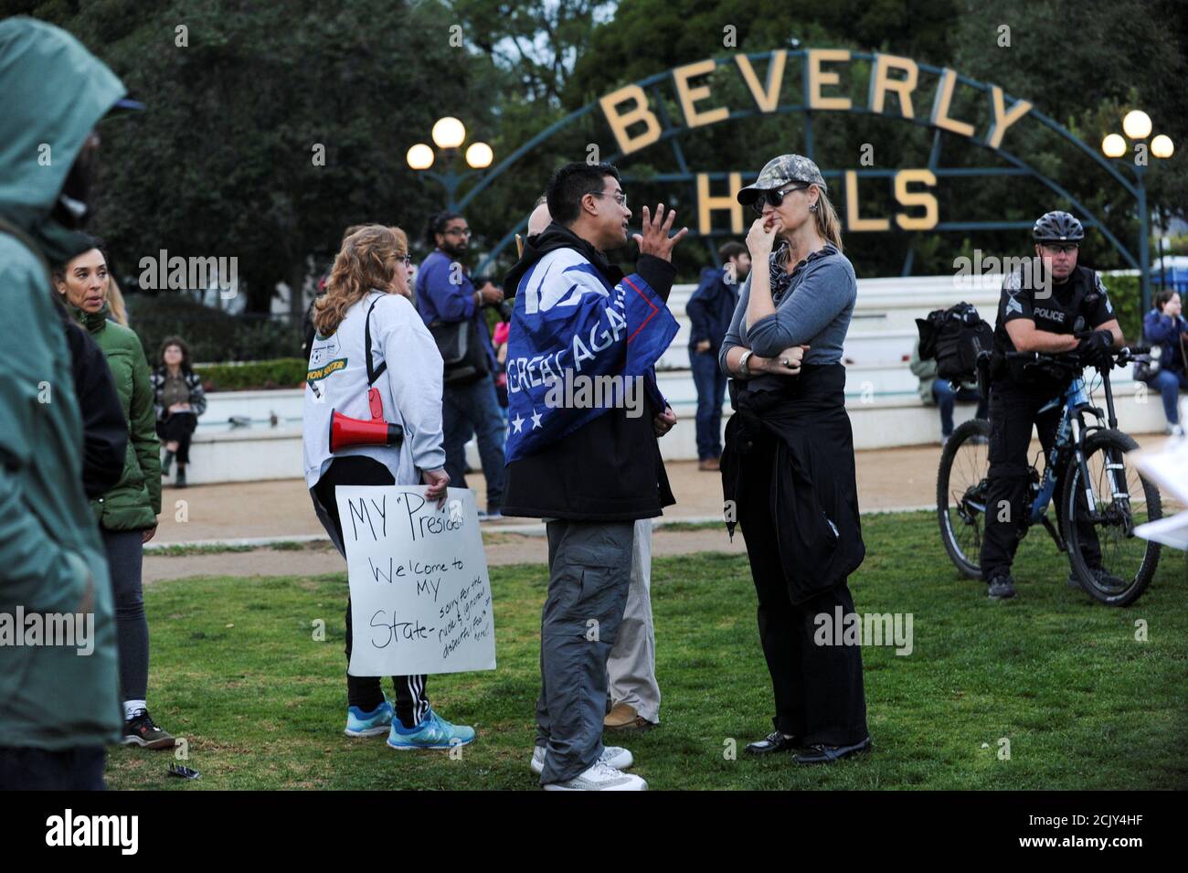 Melanie Chapman (R) talks with Danny Rodriguez (C), a Trump supporter, at an anti-Trump protest in a park a few miles from a gated community where U.S. President Donald Trump is holding a fundraiser in Beverly Hills, California, U.S. March 13, 2018. REUTERS/Andrew Cullen Stock Photo