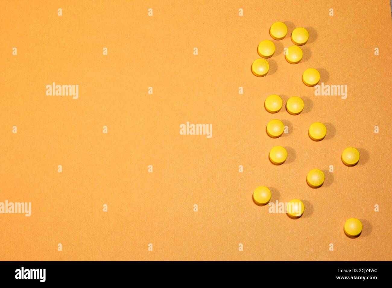 Yellow round tablets on a yellowackground. Abstract background. A