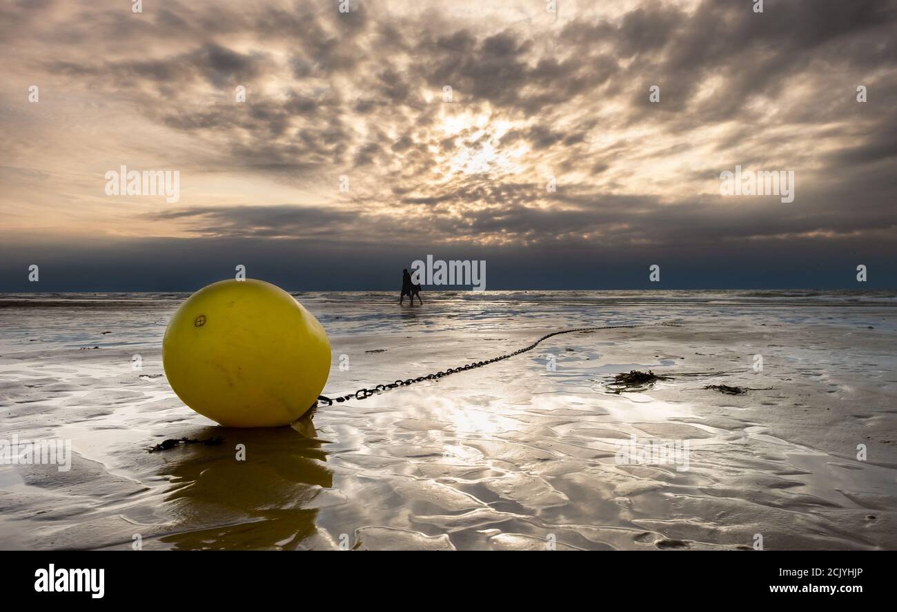 Buoy on a beach at sunset. Stock Photo