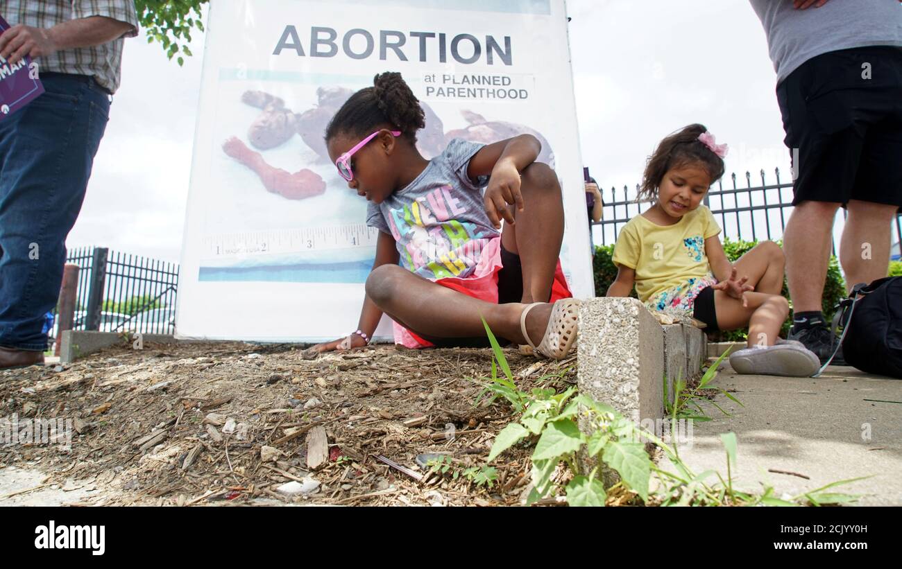 A young girl sits in front of an anti-abortion rights sign at a rally in front of Planned Parenthood in St. Louis, Missouri, U.S., June 4, 2019. REUTERS/Lawrence Bryant Stock Photo