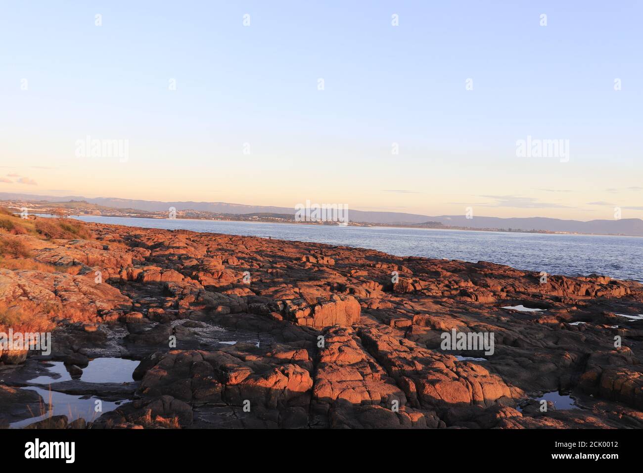 Beautiful shot of a rocky seashore with an ocean at sunset Stock Photo ...