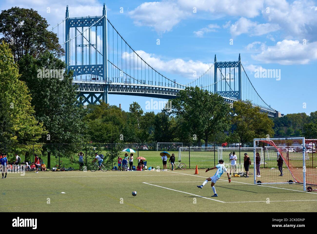WARDS ISLAND, NY USA - SEPTEMBER 12 2020: Athletes playing soccer on the fields at Wards Island, NYC, with the Robert F. Kennedy Bridge in the backgro Stock Photo