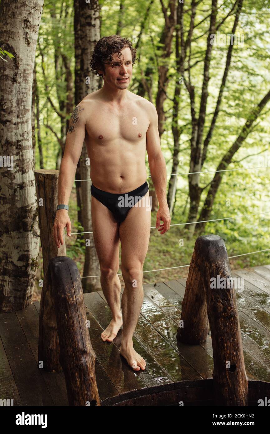 happy student is standing on the wooden floor and going to dive in the swiming pool. full length photo.green forest on the background of the photo. Stock Photo