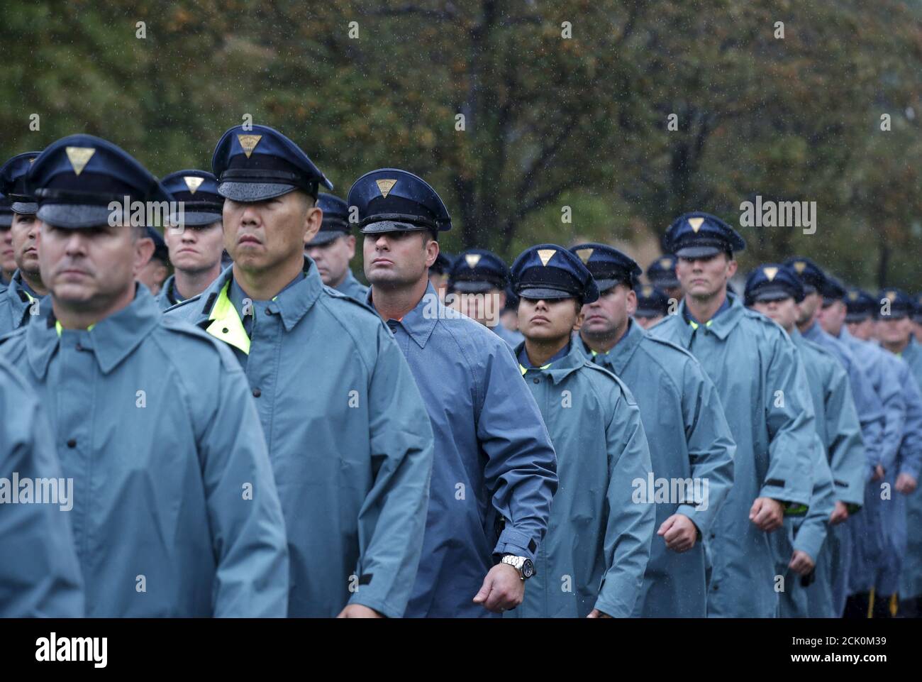 New York State Police officers march in the rain near the Greater Allen