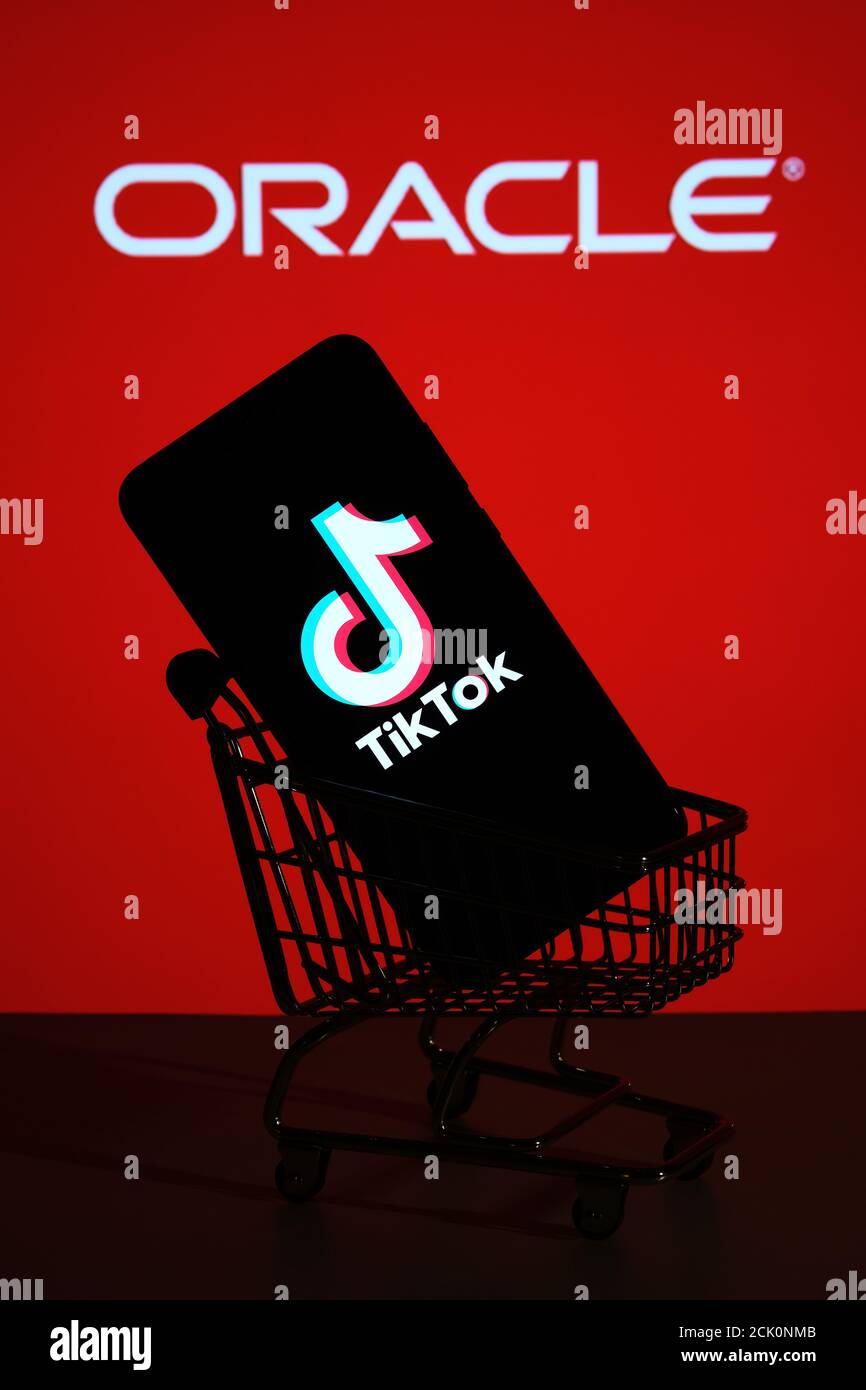 Stafford / UK - September 15 2020: TikTok acquisition by Oracle, concept. TikTok logo seen on the smartphone placed in miniature shopping trolley and Stock Photo