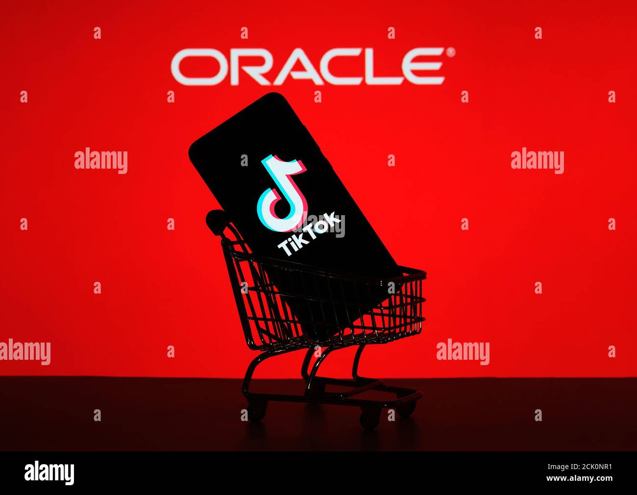 Stafford / UK - September 15 2020: TikTok acquisition by Oracle, concept. TikTok logo seen on the smartphone placed in miniature shopping trolley and Stock Photo