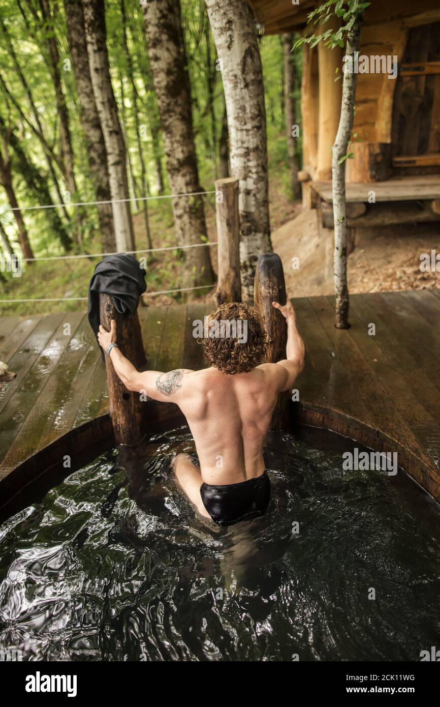 young brutal man has finished to take a bath. back view photo. Stock Photo