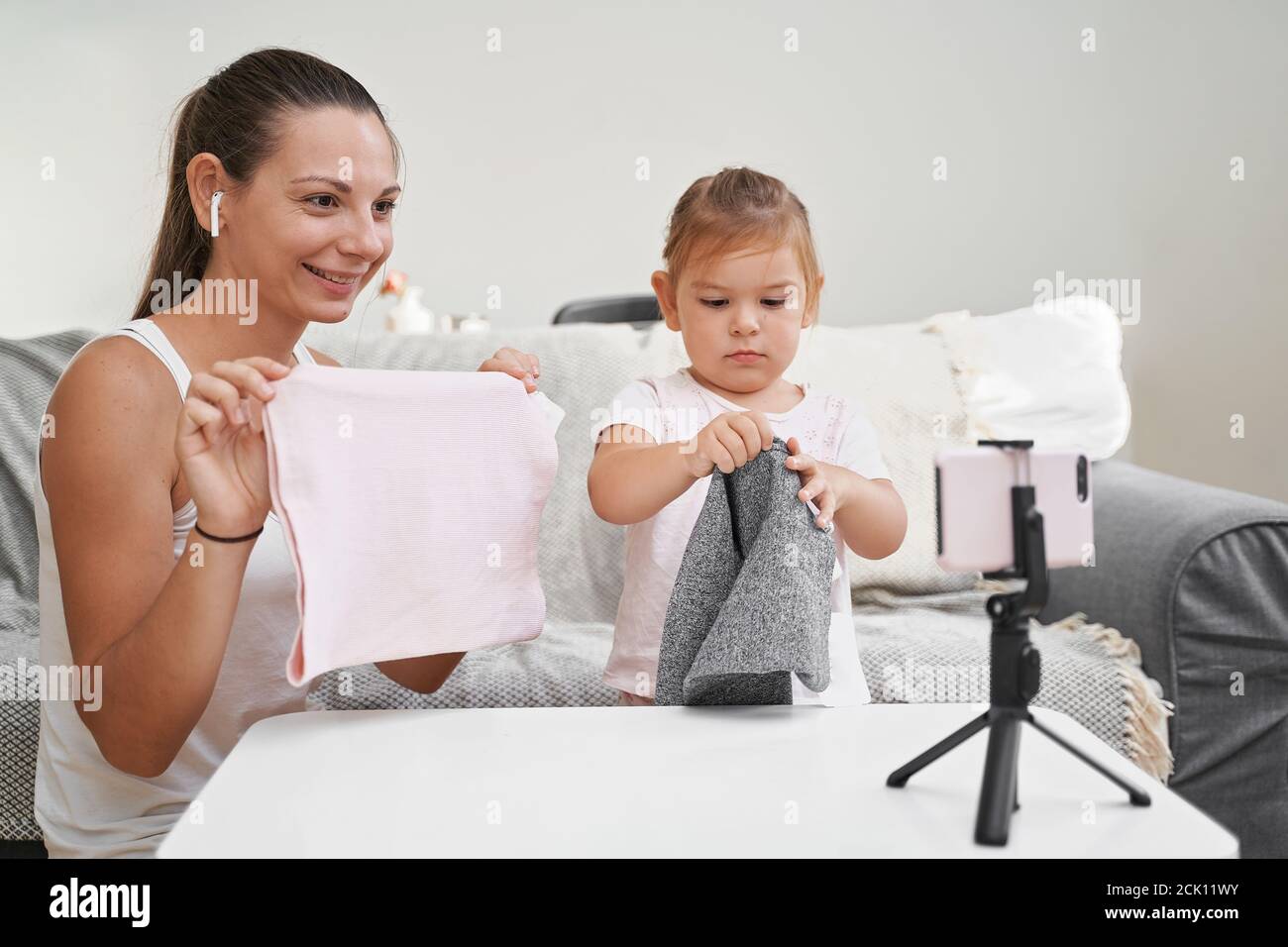 Mother with child streaming online video of unboxing clothes. Influencer  occupation, mommy blog Stock Photo - Alamy