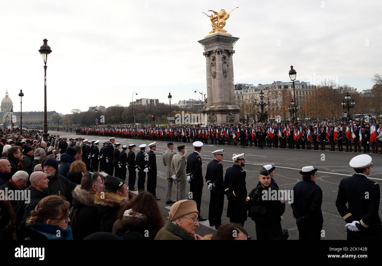 Soldiers and citizens stand on the Alexandre III bridge during a funeral convoy with the coffins of late thirteen French soldiers killed in Mali before a ceremony at the Hotel National des Invalides in Paris, France, December 2, 2019. French soldiers Julien Carrette, Benjamin Gireud, Romain Salles de Saint-Paul, Clement Frison-Roche, Nicolas Megard, Romain Chomel de Jarnieu, Pierre Bockel, Alex Morisse, Jeremy Leusie, Alexandre Protin, Antoine Serre, Valentin Duval, Andrei Jouk died in Mali when their helicopters collided in the dark last week as they hunted for Islamist militants.   REUTERS/G Stock Photo