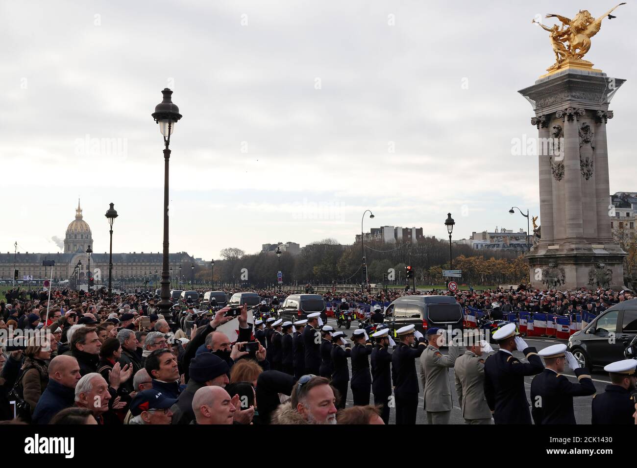 Soldiers and citizens pay tribute as hearses with the coffins of late thirteen French soldiers killed in Mali make their way past the Alexandre III bridge before a ceremony at the Hotel National des Invalides in Paris, France, December 2, 2019. French soldiers Julien Carrette, Benjamin Gireud, Romain Salles de Saint-Paul, Clement Frison-Roche, Nicolas Megard, Romain Chomel de Jarnieu, Pierre Bockel, Alex Morisse, Jeremy Leusie, Alexandre Protin, Antoine Serre, Valentin Duval, Andrei Jouk died in Mali when their helicopters collided in the dark last week as they hunted for Islamist militants.   Stock Photo