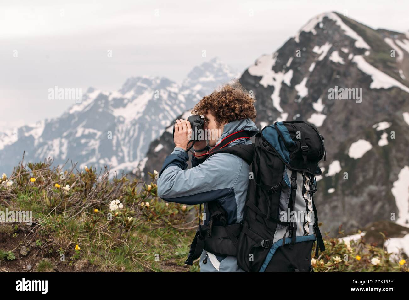 close up back view photo of a young photographer with rucksack taking ...