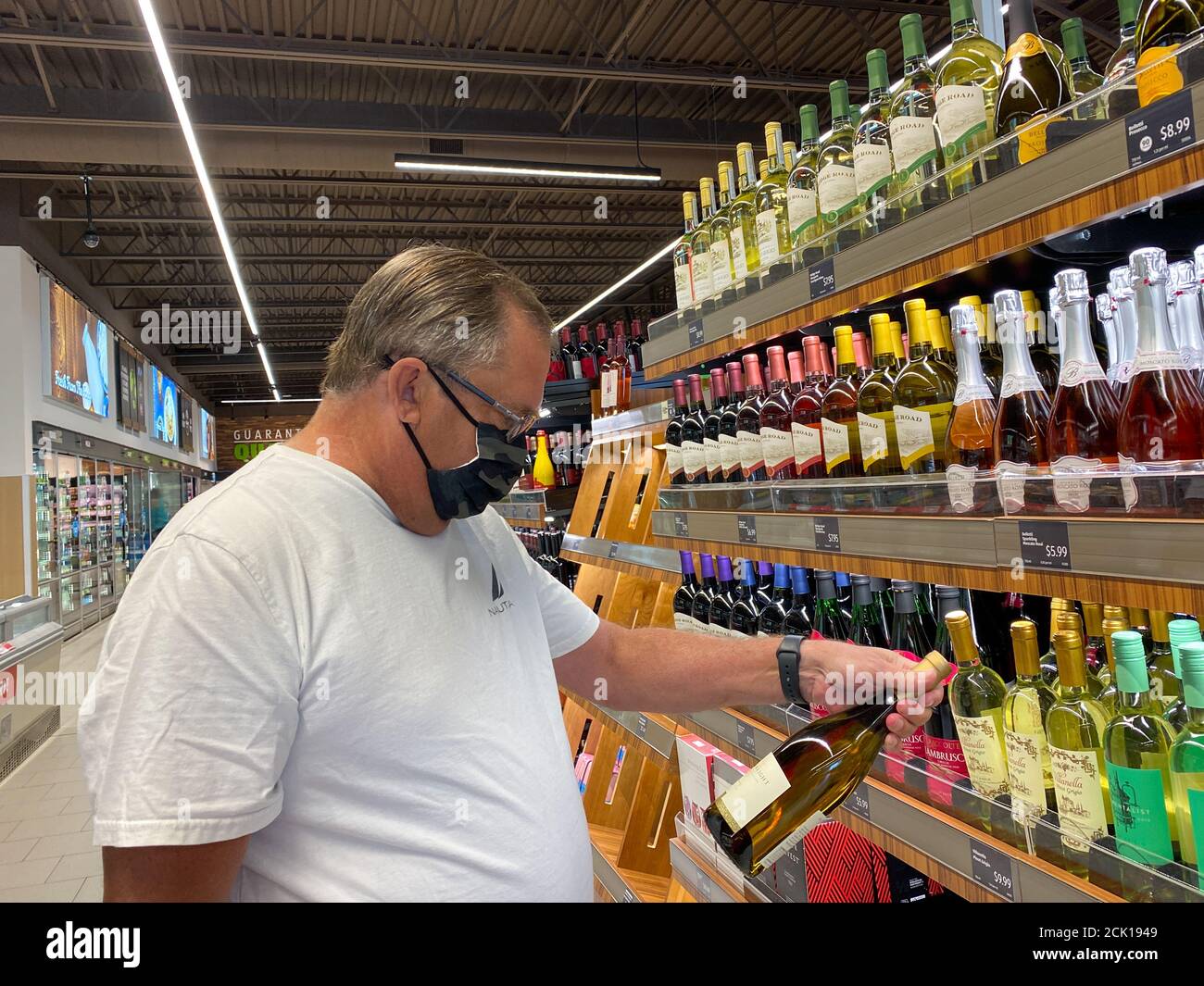 Orlando,FL/USA -8/6/20: A man looking at a bottle of wine in the wine aisle  at an Aldi grocery store in Orlando, Florida. Stock Photo