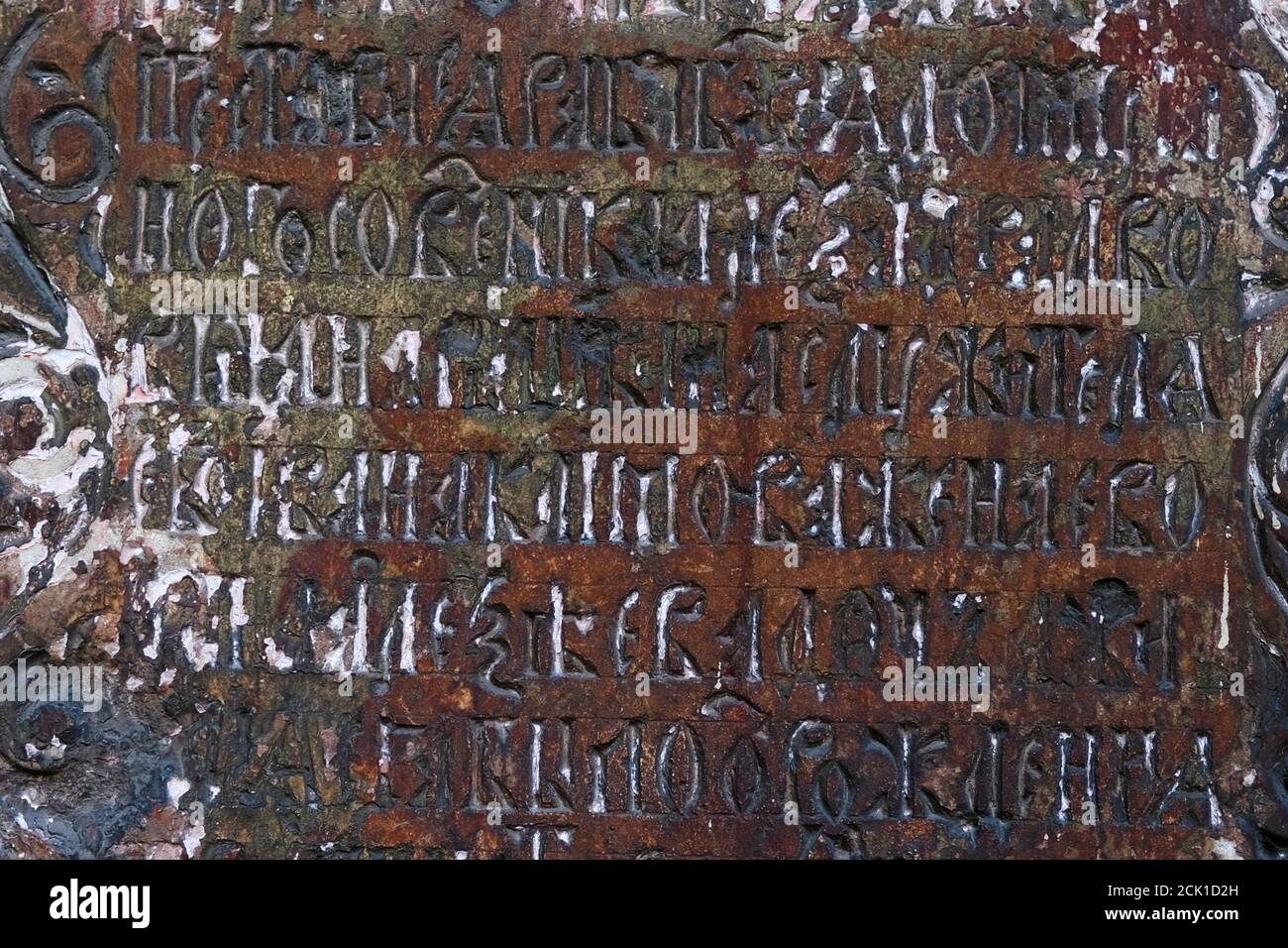 Fragment of Cyrillic Old Slavic letter on weathered stone slab on wall of ancient temple.  Stock Photo