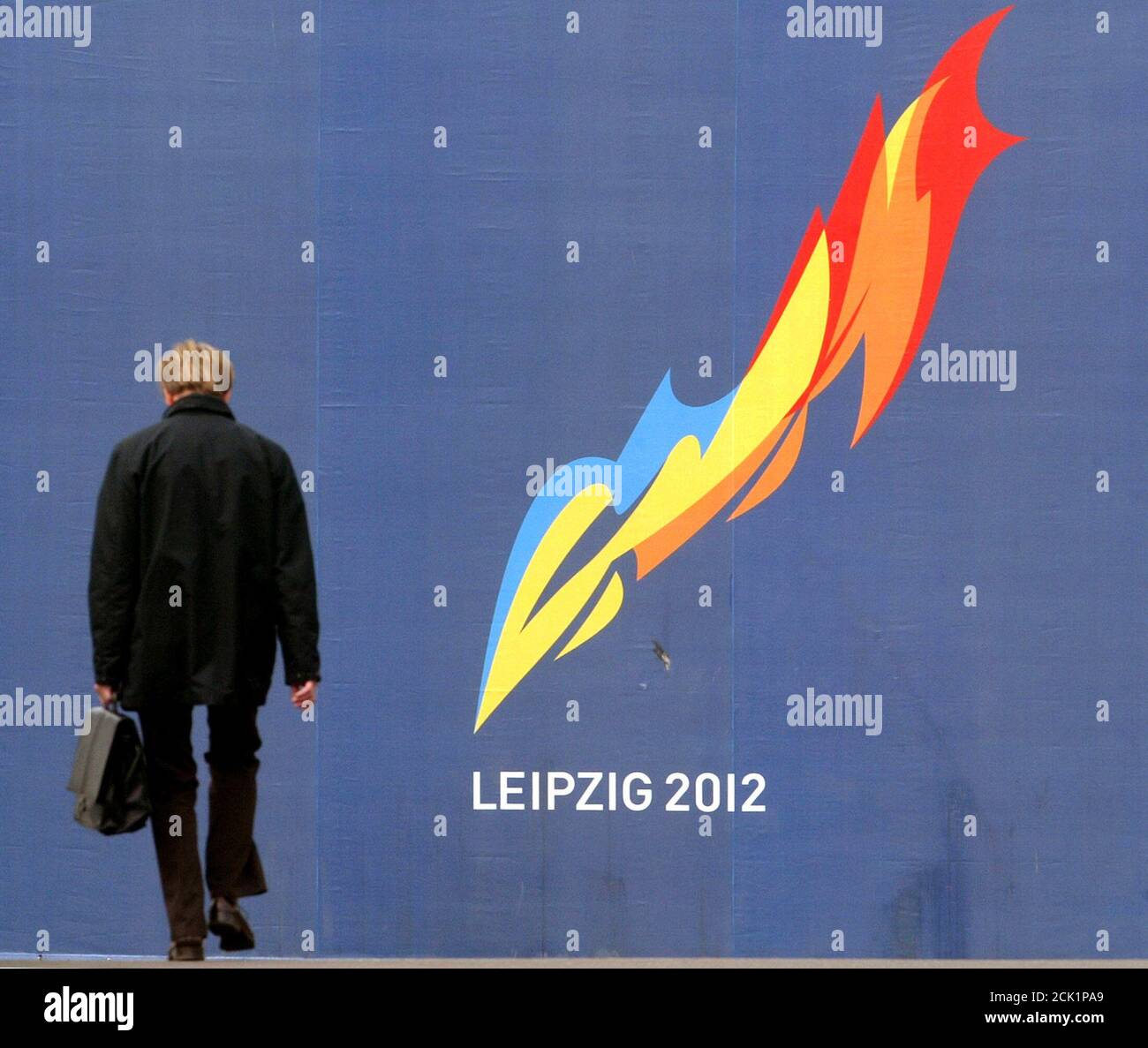 A man walks in front of an advertising poster for the city of Leipzig's application to host the 2012 Olympics in the eastern German city of Leipzig May 17, 2004. Nine cities hoping to stage the 2012 Olympic Games face a cull this week as Olympic chiefs meet to draw up a shortlist of candidates. The applicants - Havana, Istanbul, Leipzig, London, Madrid, Moscow, New York City, Paris and Rio de Janeiro - will learn their fate on Tuesday. REUTERS/Arnd Wiegmann  AKW/JOH/ACM Stock Photo
