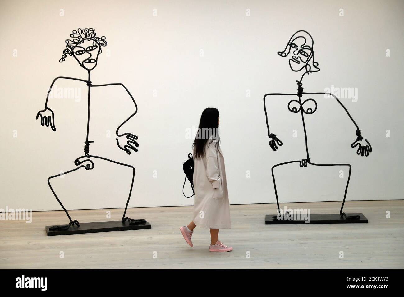 A woman looks 'The Simple Ones' by Tim Noble and Sue Webster during a