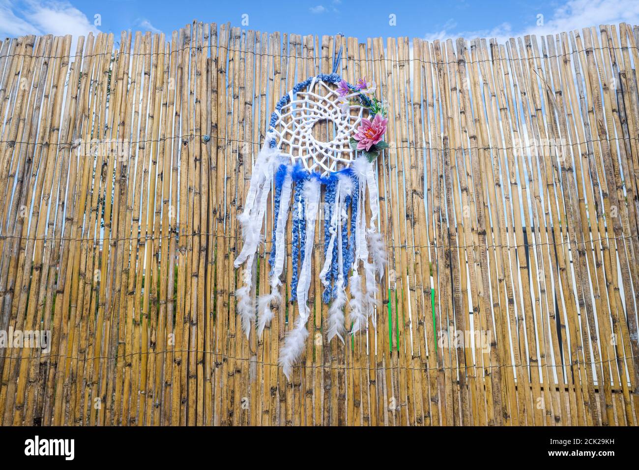 Vintage indigenous decoration hanging from a wall of old reeds, intense ...