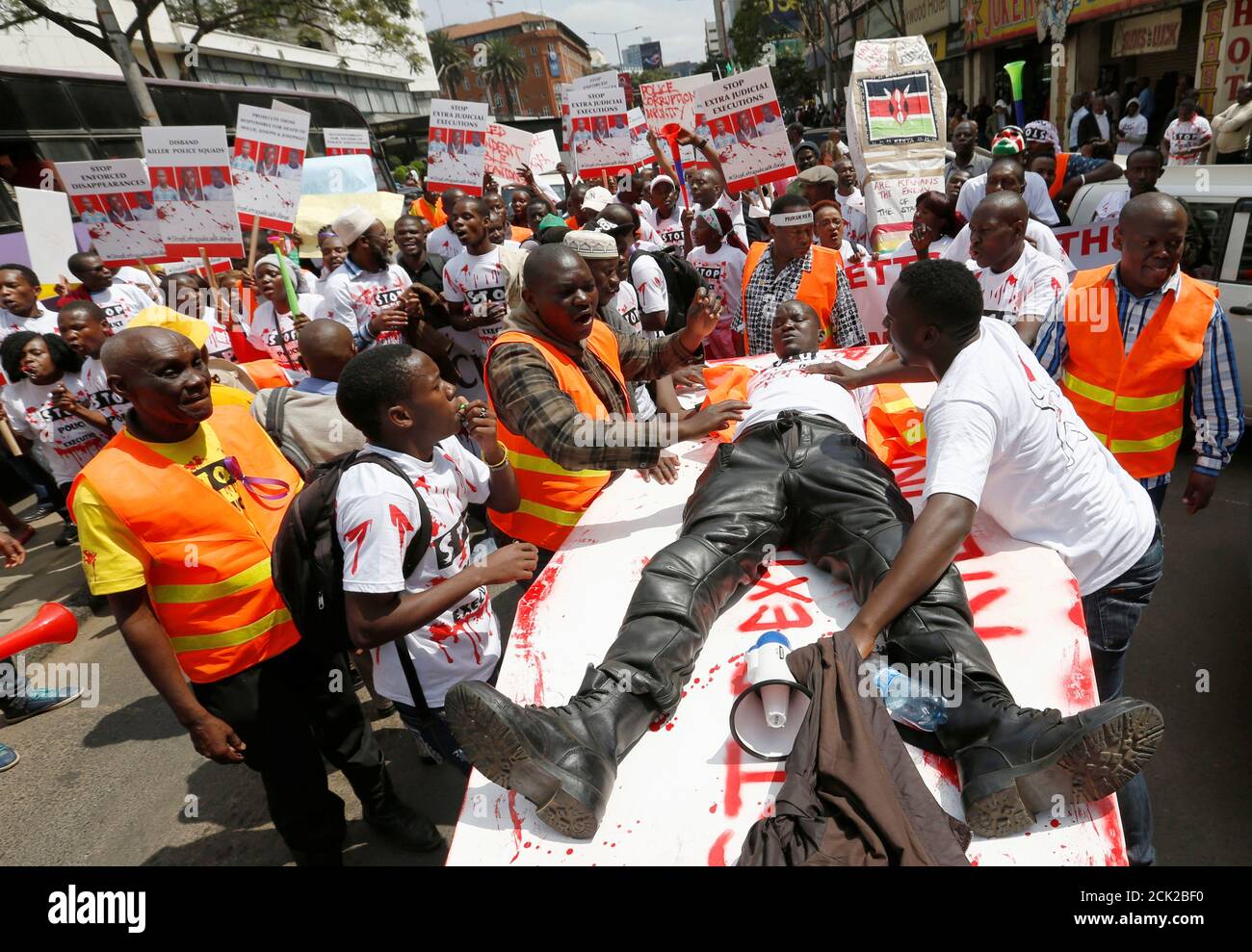 A member of the civil society lies on top of a mock coffin stained with mock blood, as others chant slogans during a protest dubbed 'Stop extrajudicial killings' on the killing of human rights lawyer, Willie Kimani, his client and their driver in Nairobi, Kenya, July 4, 2016. REUTERS/Thomas Mukoya     TPX IMAGES OF THE DAY Stock Photo