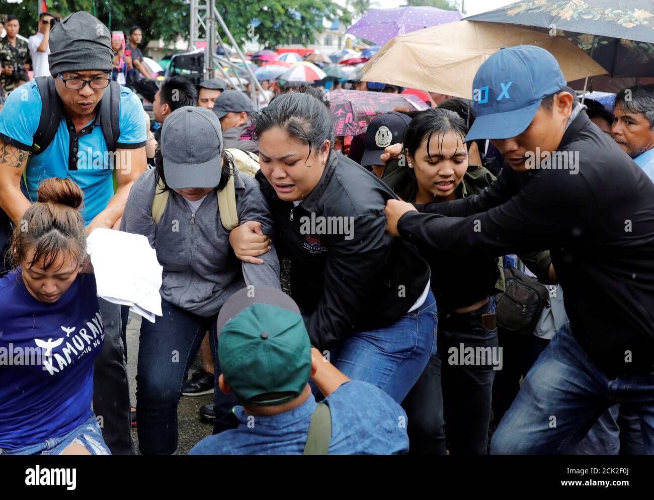 Plainclothes policemen lead away activists who heckled President Rodrigo Duterte while speaking during the 120th Philippine Independence day celebration at the Emilio Aguinaldo shrine in Kawit, Cavite Philippines June 12, 2018. REUTERS/Erik De Castro Stock Photo