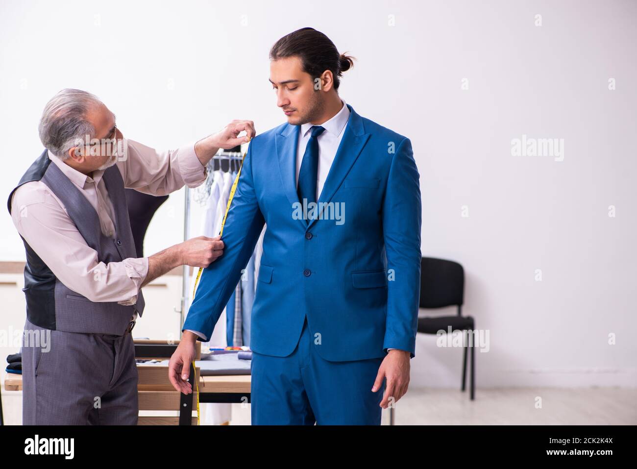 Young businessman visiting old tailor Stock Photo