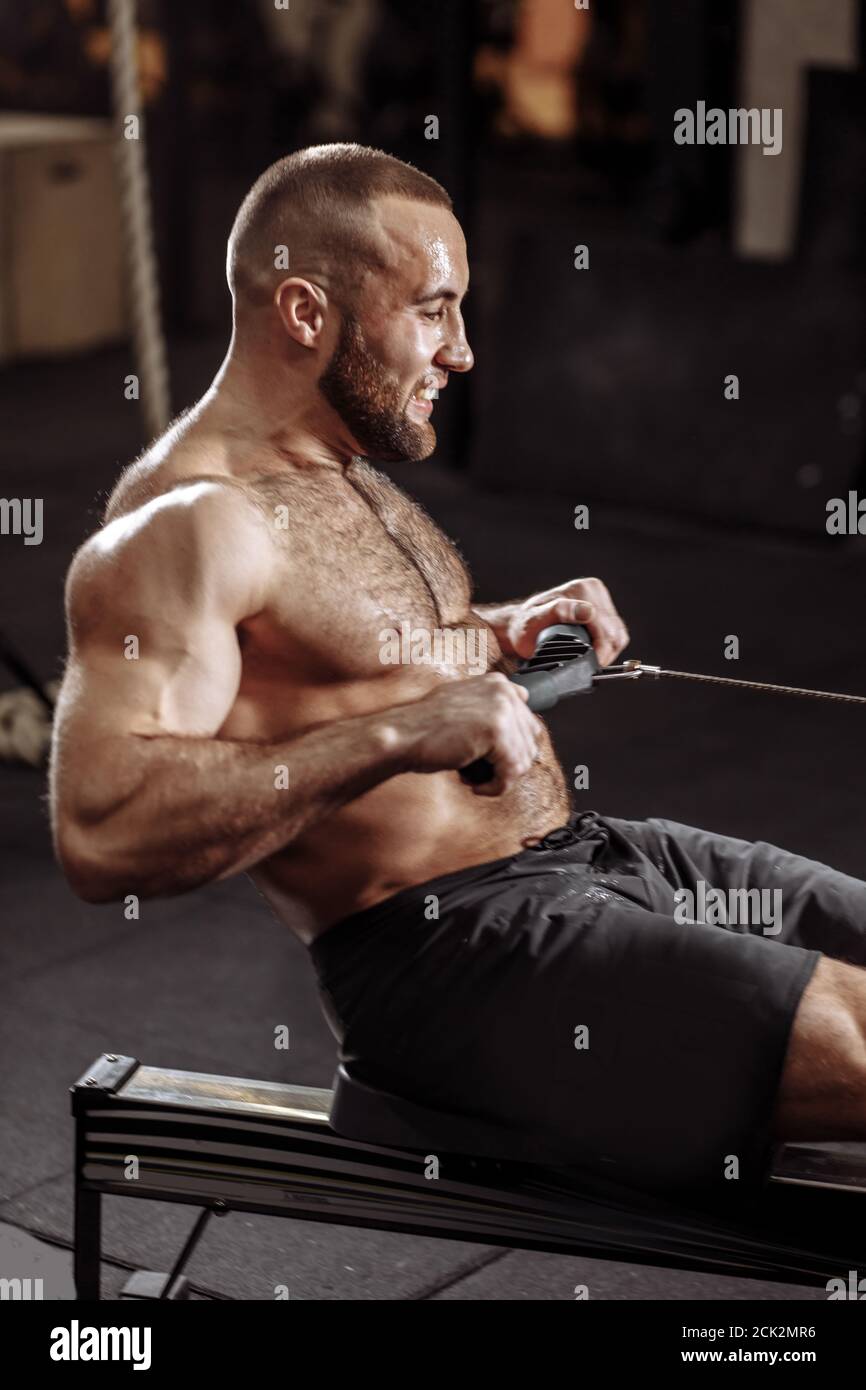 sweaty guy with clenched teeth working out in the fitness center. close up side view photo Stock Photo