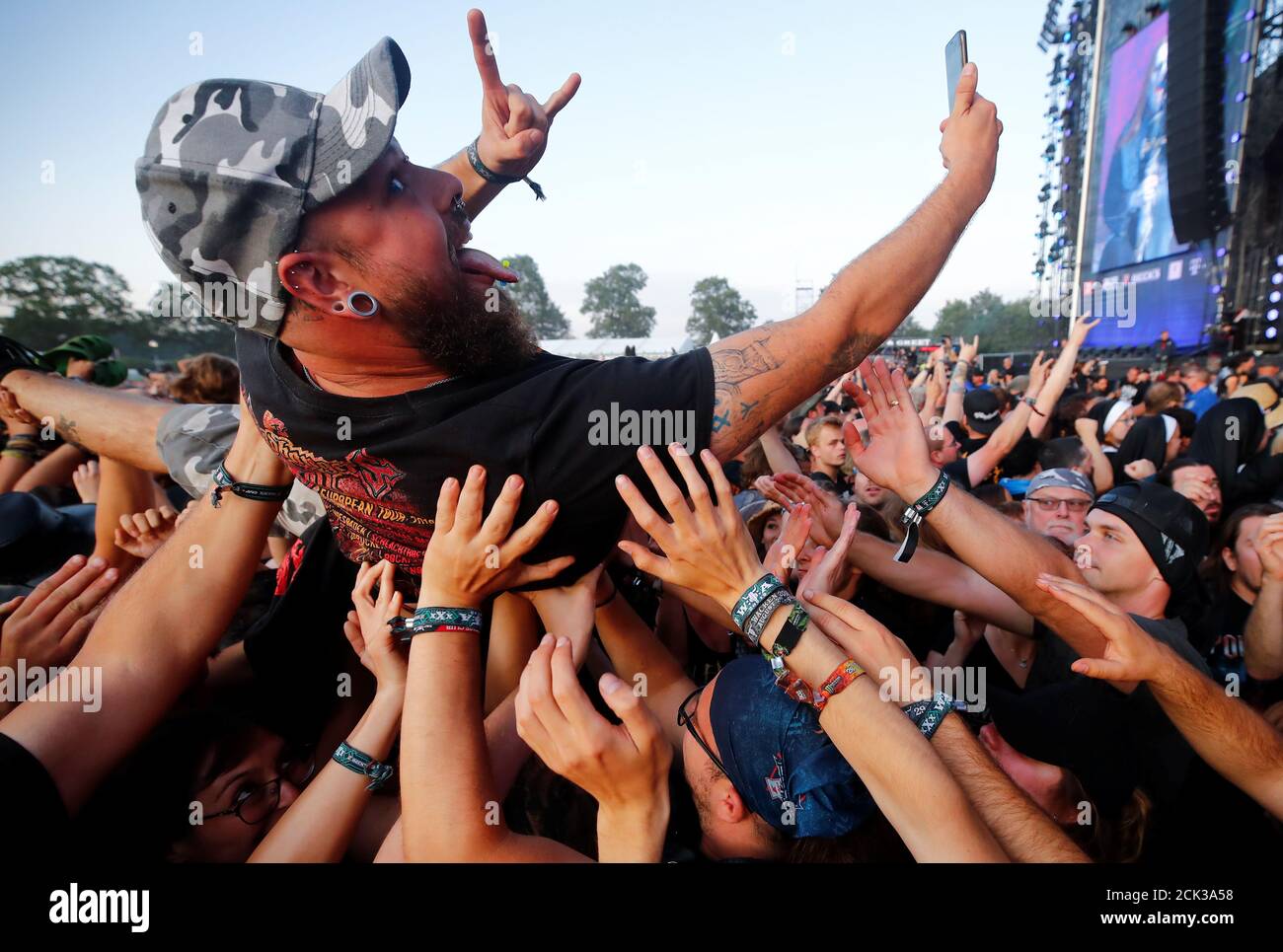 A fan takes a selfie as he surfs on top of the crowd during the performance