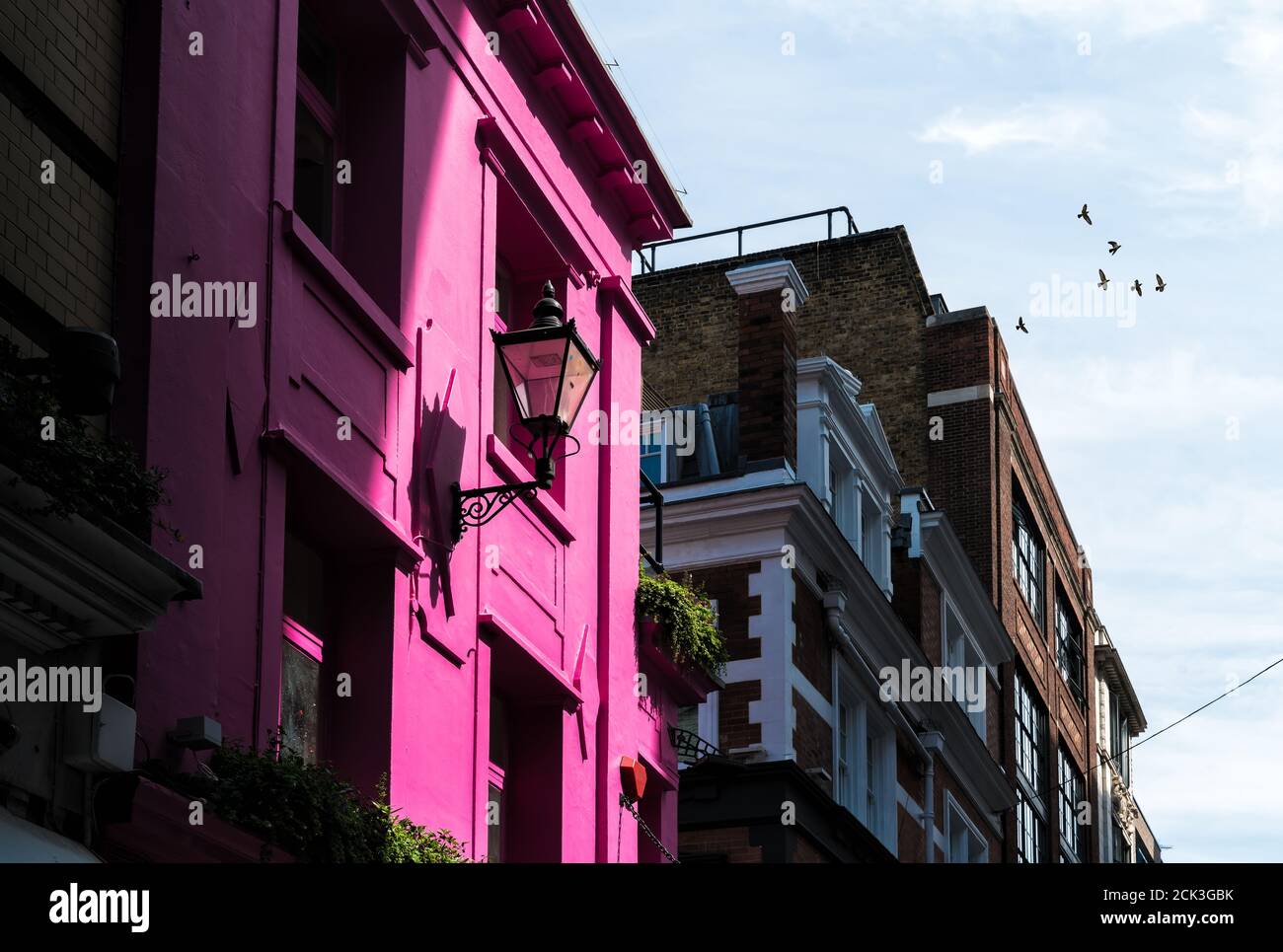 Glowing Pink Colour House with Sunlight in Urban Setting, London UK Stock Photo