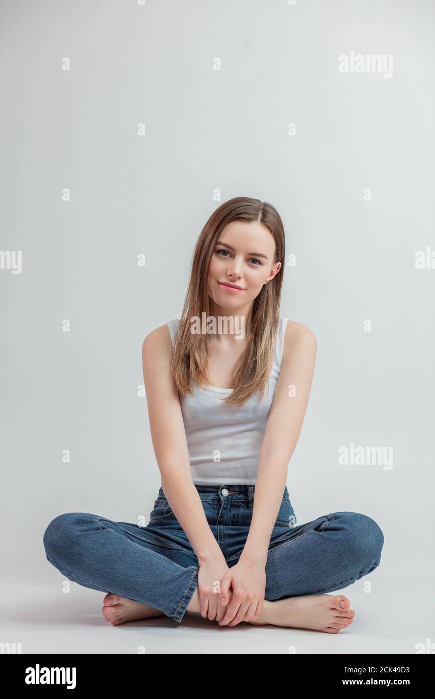 happy young woman in casual clothes sitting with crossed legs in the studio.full length Stock Photo