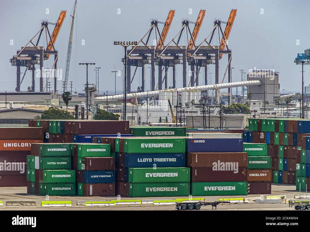 Los Angeles, USA - April 20, 2008: San Pedro harbor. Detail of Evergreen container yard with stacks of boxes and cranes under light blue sky. Stock Photo