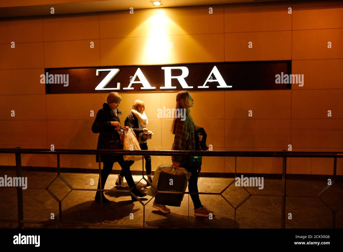 People walk past with their shopping bags a Zara logo in the Andalusian  capital of Seville, southern Spain March 4, 2016. REUTERS/Marcelo del Pozo  Stock Photo - Alamy
