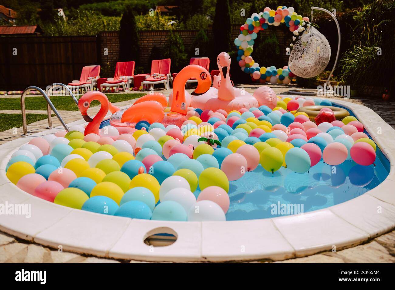 Beautifully decorated yard with pool balloons and pink flamingos. Garden  decoration for a summer party Stock Photo - Alamy