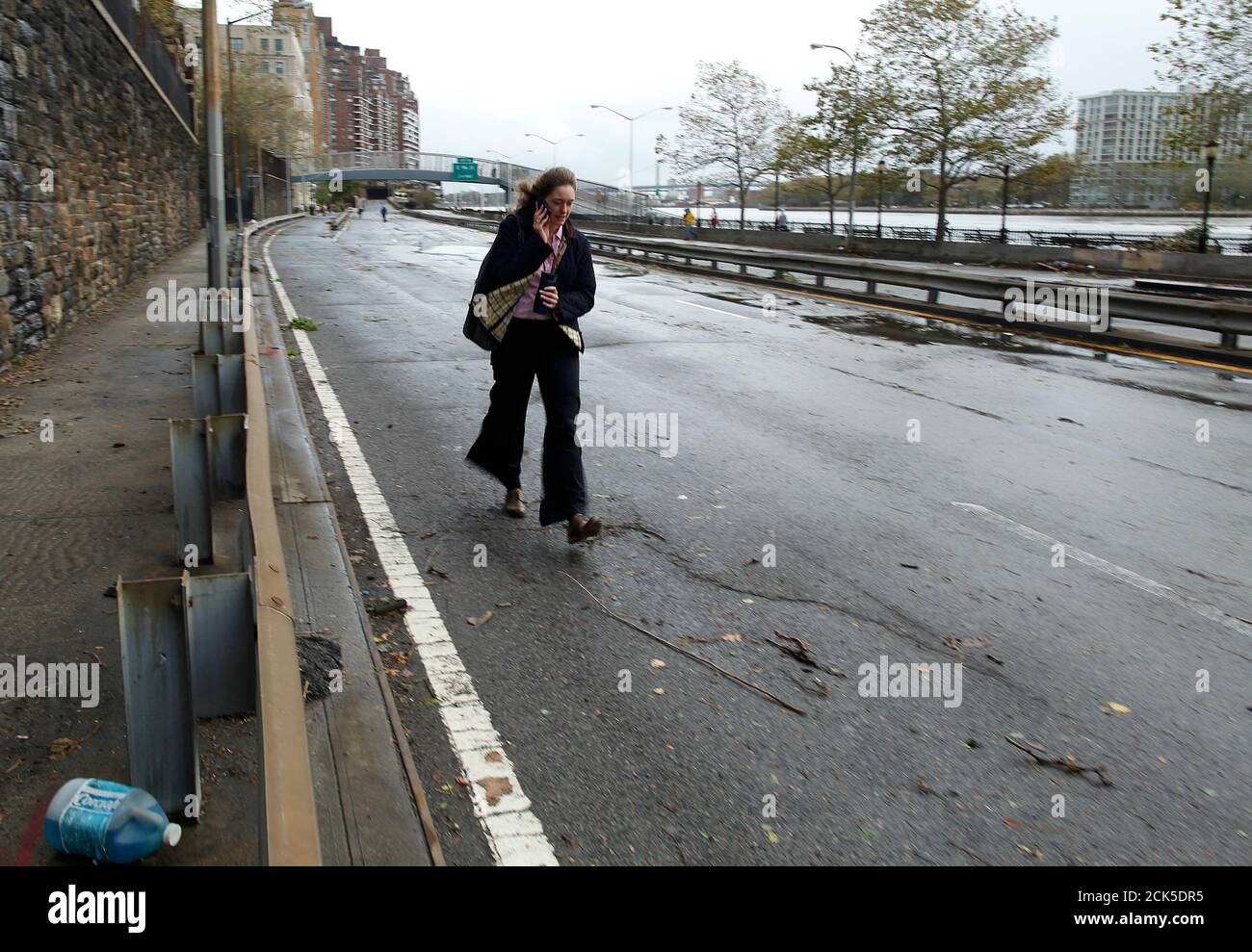 A woman walks along FDR Drive on the Upper East Side in the aftermath of Hurricane Sandy in New York October 30, 2012. Almost the entire length of the FDR was flooded.  REUTERS/Carlo Allegri  (UNITED STATES - Tags: ENVIRONMENT DISASTER) Stock Photo
