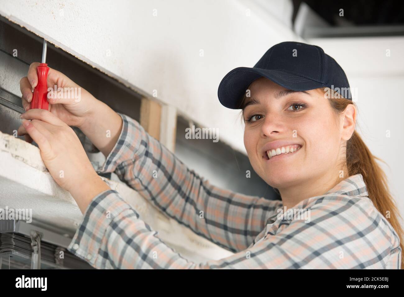 woman installing blinds with screwdriver Stock Photo