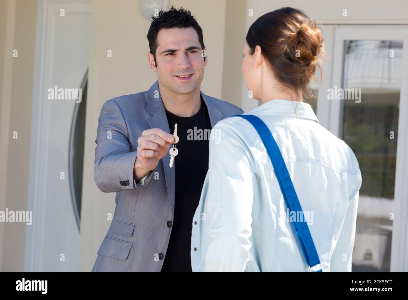 real estate agent giving keys to woman Stock Photo - Alamy