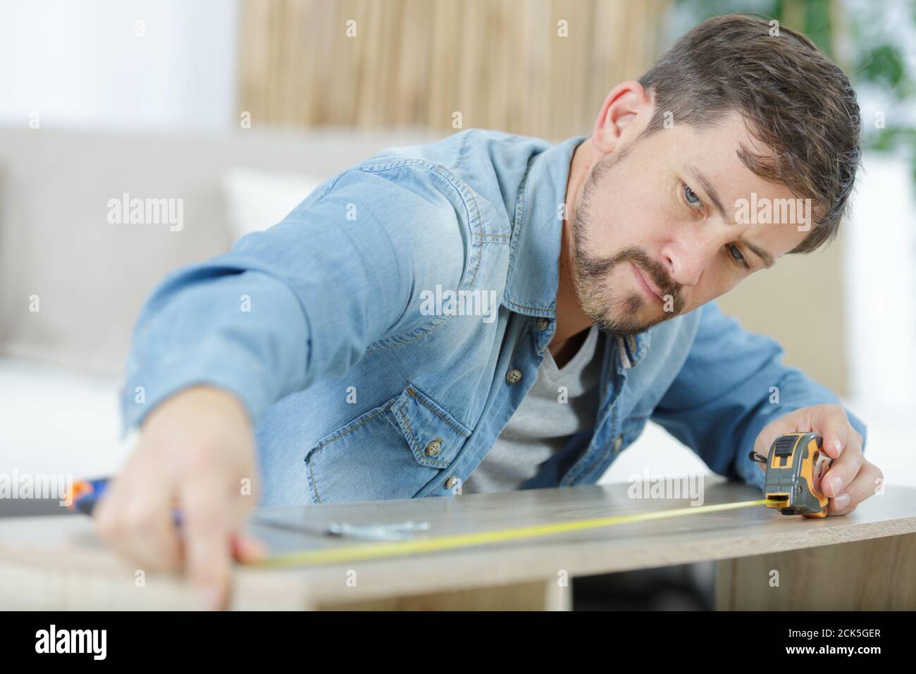 man measures dimension with a tape measure Stock Photo Alamy