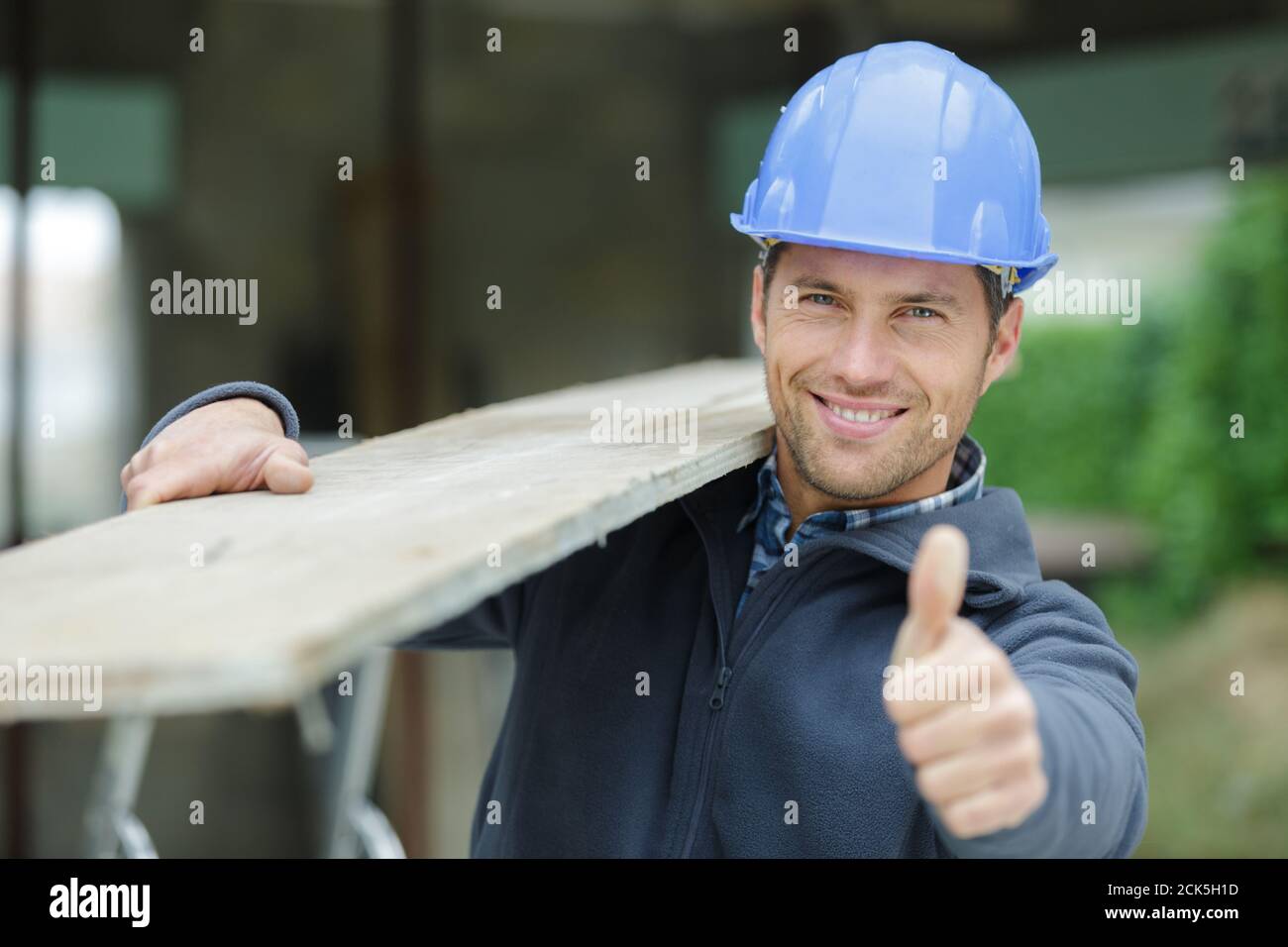 furniture maker carrying wood planks on his shoulder Stock Photo Alamy