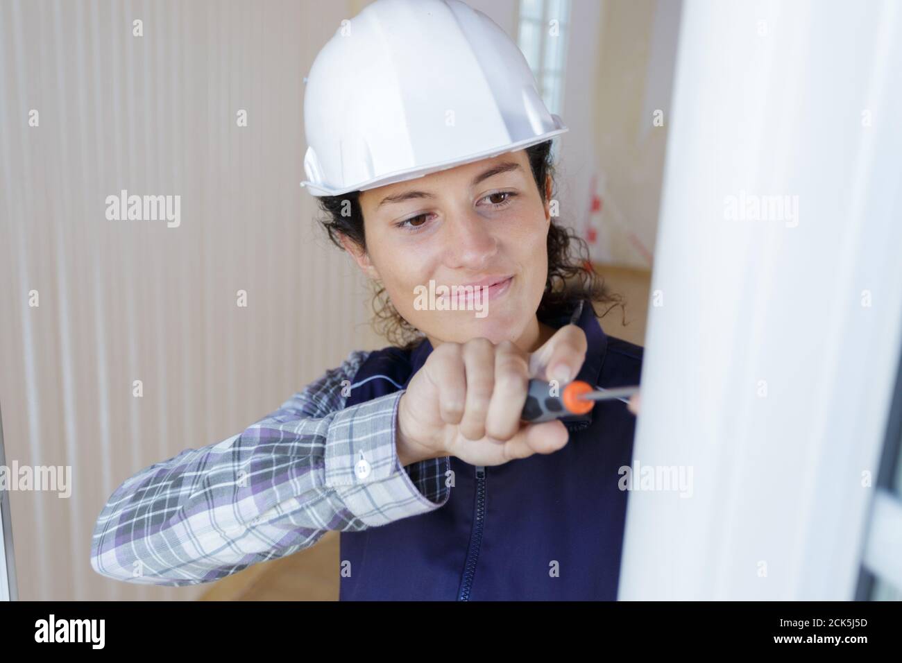 woman installing blinds with screwdriver Stock Photo