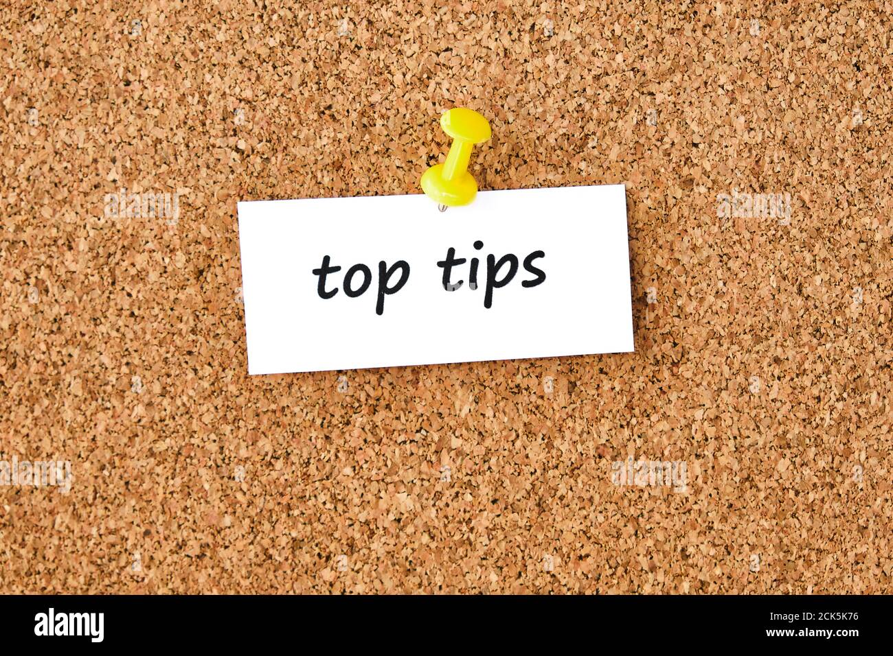 Top tips. Text written on a piece of paper or note, cork board ...