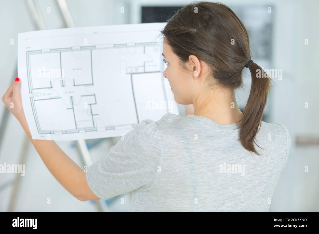 thoughtful female architect looking on blueprint Stock Photo