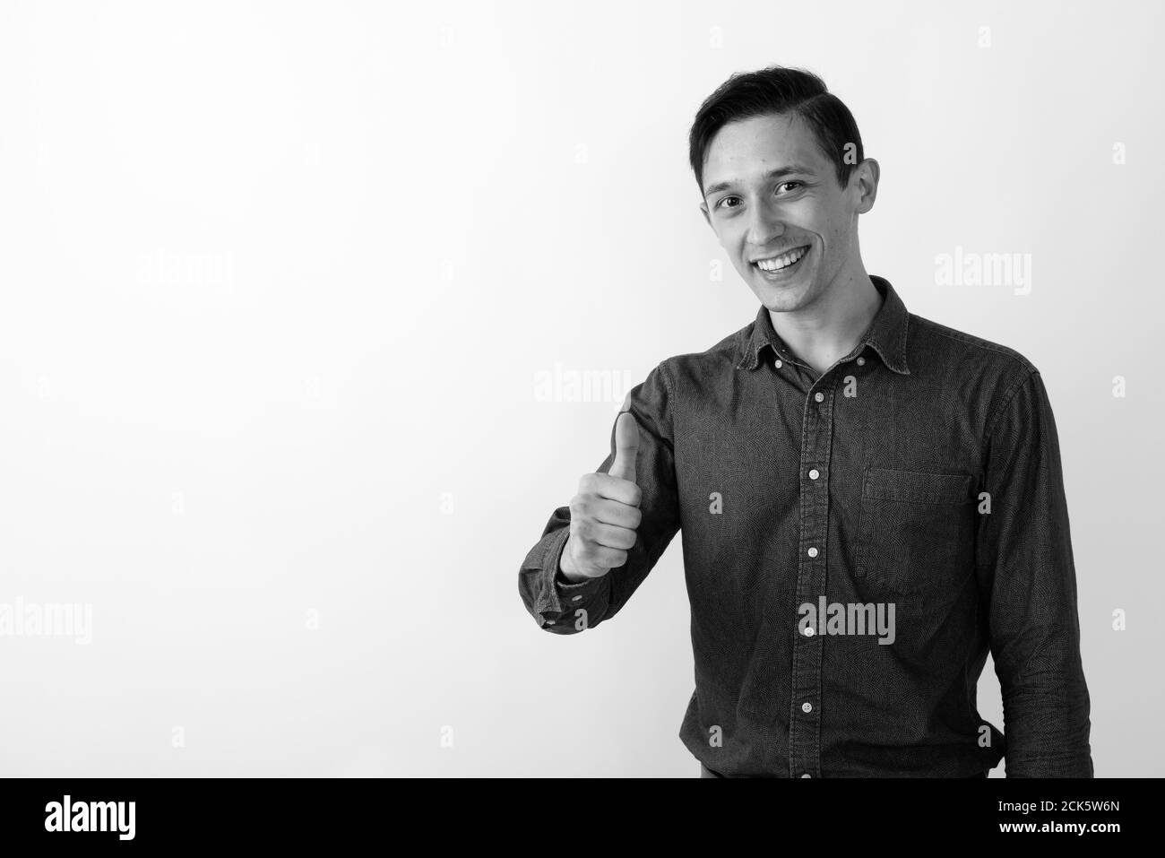 Studio shot of happy young handsome man smiling and giving handshake ...