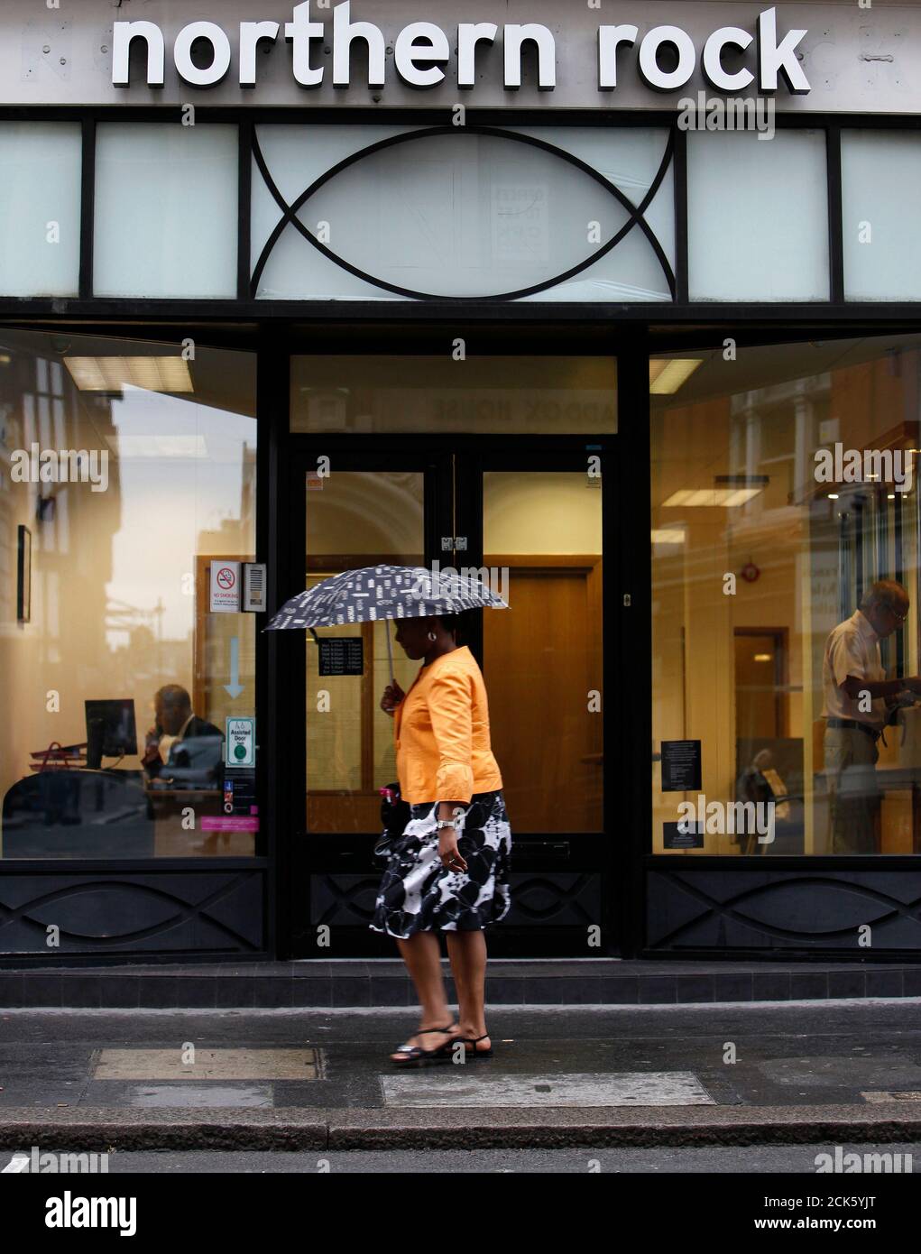 A pedestrian walks past a branch of the Northern Rock bank in central London August 4, 2009. British bank Northern Rock said on Tuesday its first-half losses rose almost 24 percent, as delays to EU approval for its state-backed turnaround hit funding costs and held back its ability to help revive the UK mortgage market.  REUTERS/Stefan Wermuth (BRITAIN BUSINESS) Stock Photo