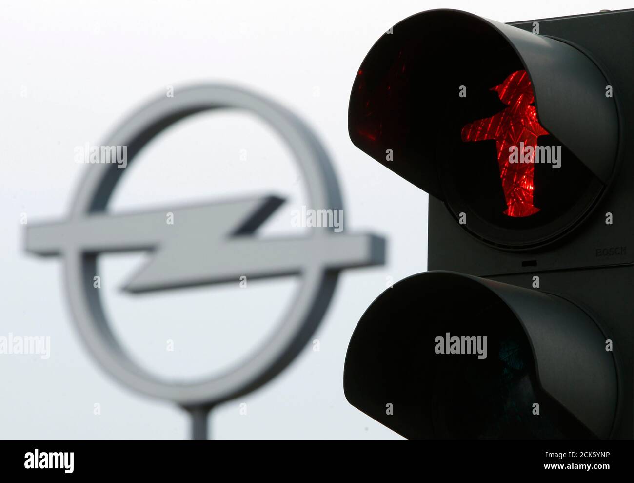 A red traffic light is seen near the logo of German car maker Opel at a automobile dealer in Berlin, June 9, 2010.  Germany's Economy Minister Rainer Bruederle said on Wednesday he had rejected a bid by carmaker General Motors for state aid for its European unit Opel. REUTERS/Thomas Peter  (GERMANY - Tags: POLITICS BUSINESS TRANSPORT IMAGES OF THE DAY) Stock Photo