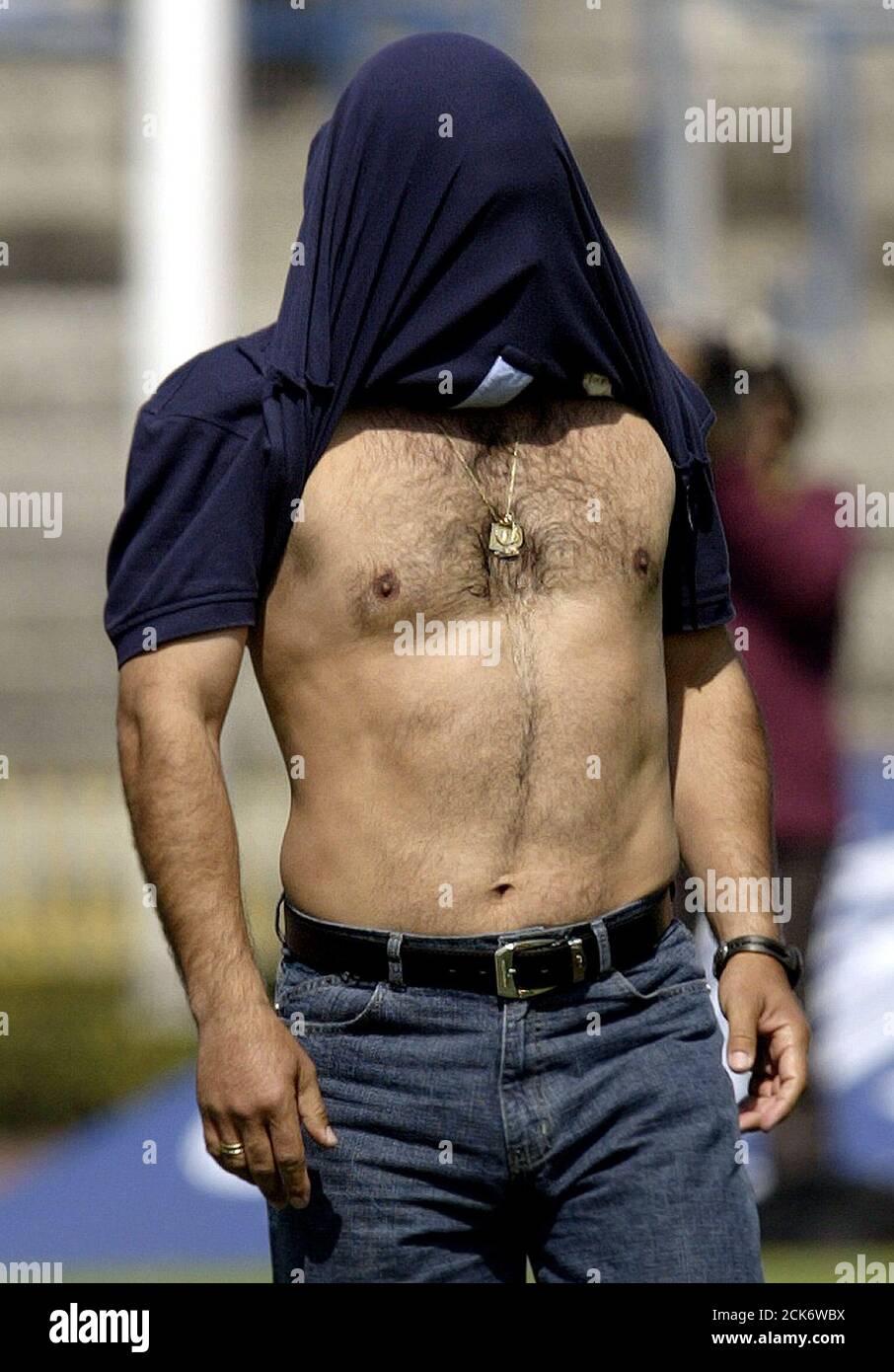 Pumas's coach Hugo Sanches covers his face with his shirt after being  ejected by the referee during the match against Chivas for the Mexican  league championship soccer match at the University stadium