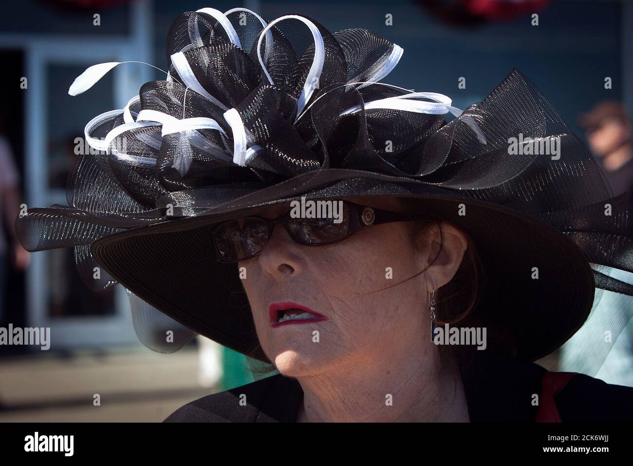 A woman wearing a hat walks though the grandstand before the 2014 Belmont Stakes in Elmont, New York June 7, 2014. REUTERS/Carlo Allegri (UNITED STATES - Tags: SPORT HORSE RACING SOCIETY) Stock Photo