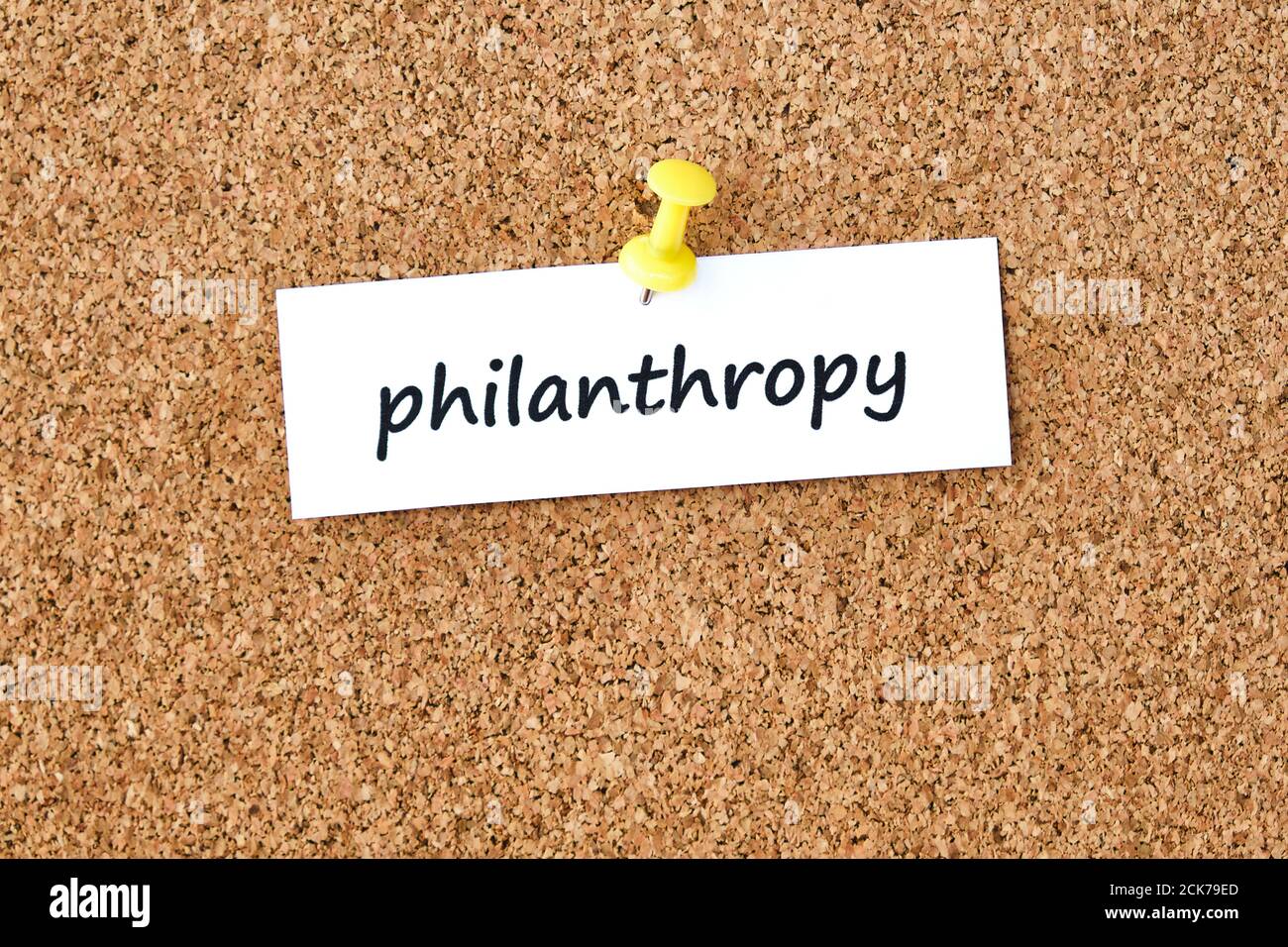 Philanthropy. Word written on a piece of paper or note, cork board
