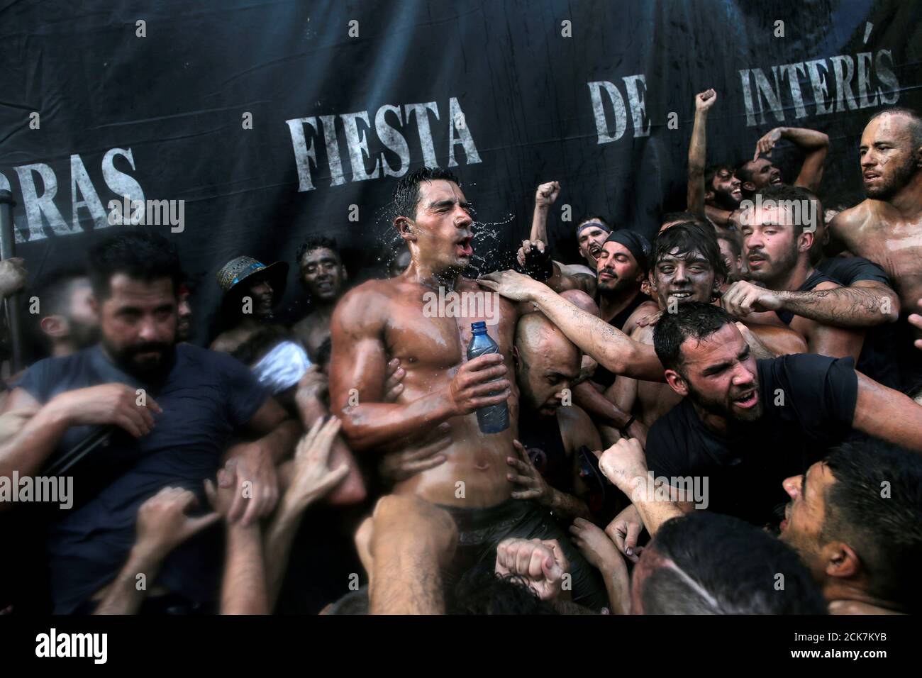 Antonio Vera, a reveller depicting the figure of Cascamorras, is surrounded  by revellers as they take